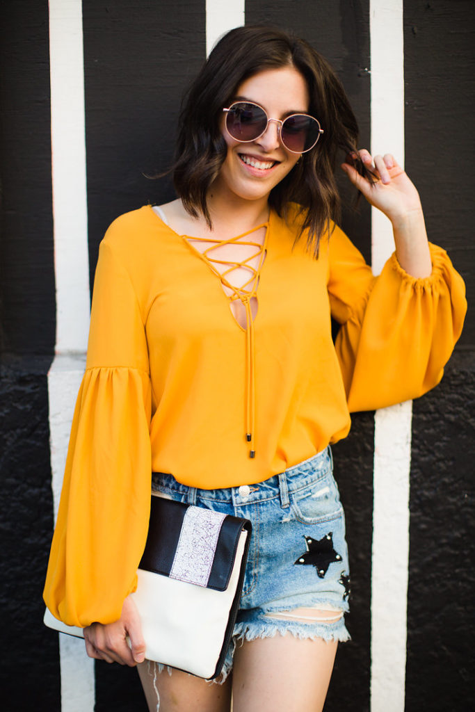 Round sunglasses Mustard yellow blouse Star Shorts