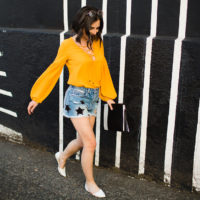 Star print denim distressed shorts and mustard lace up blouse